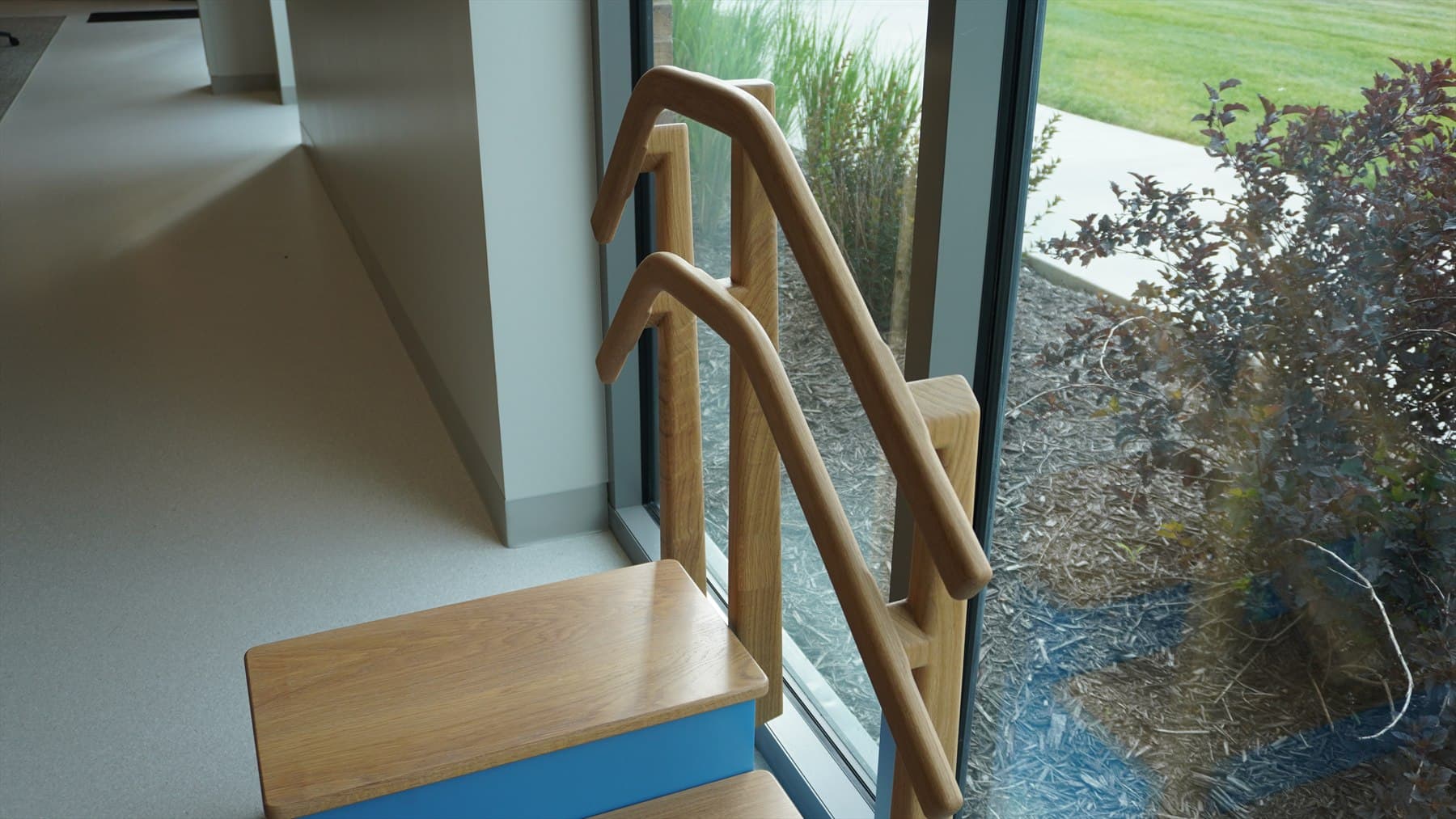 Finished wooden stair handrail project installed beside a window